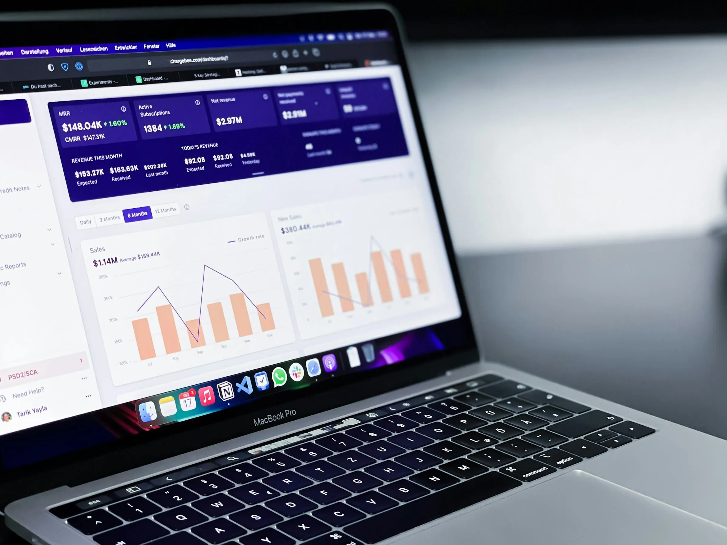 A MacBook Pro showing sales and growth charts