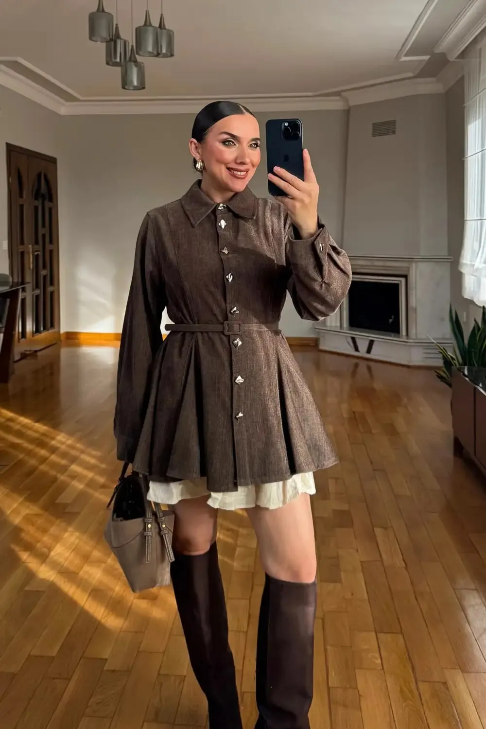 Ein Smartphone-Foto einer braunen geknöpften Jacke in einem Showroom-Spiegel