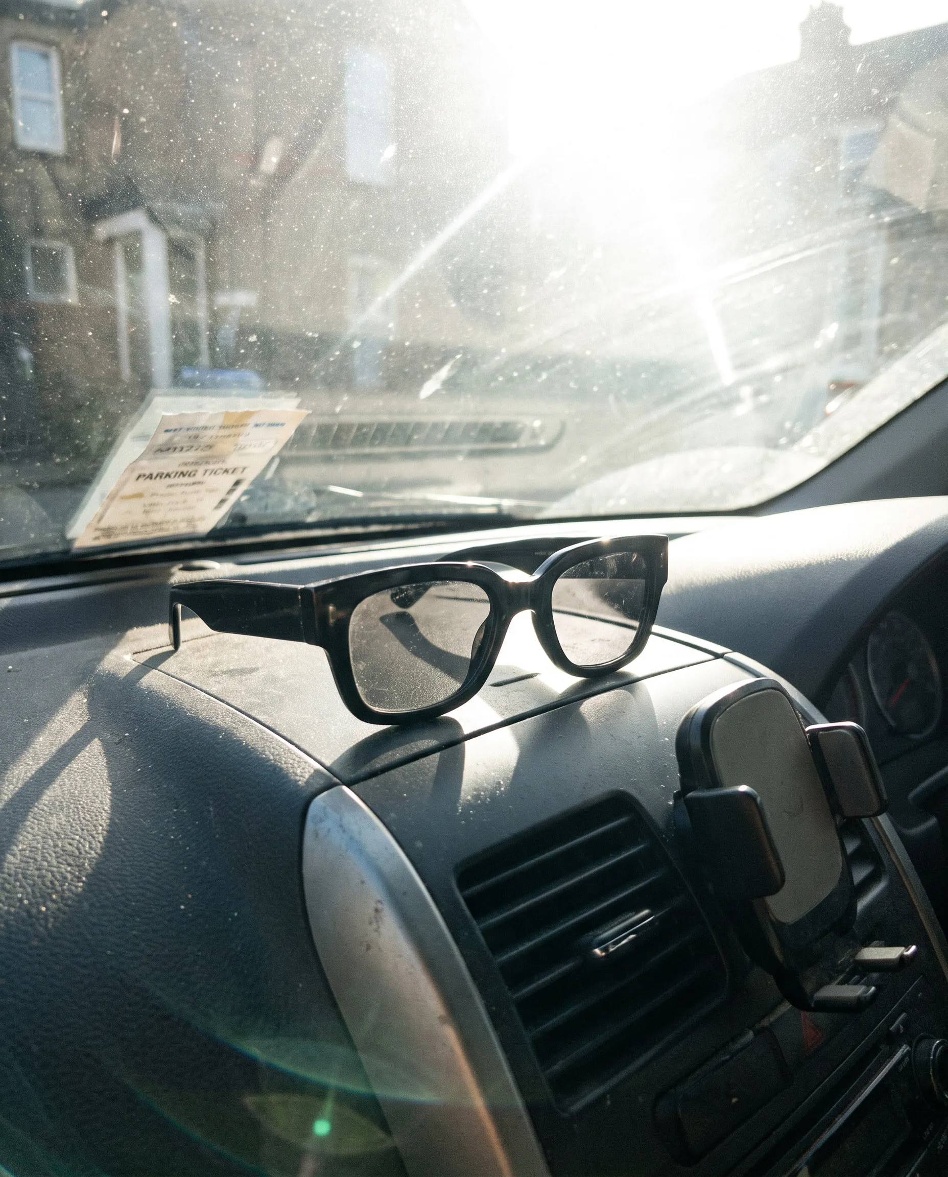 Eine schwarze Sonnenbrille auf dem Armaturenbrett eines Autos