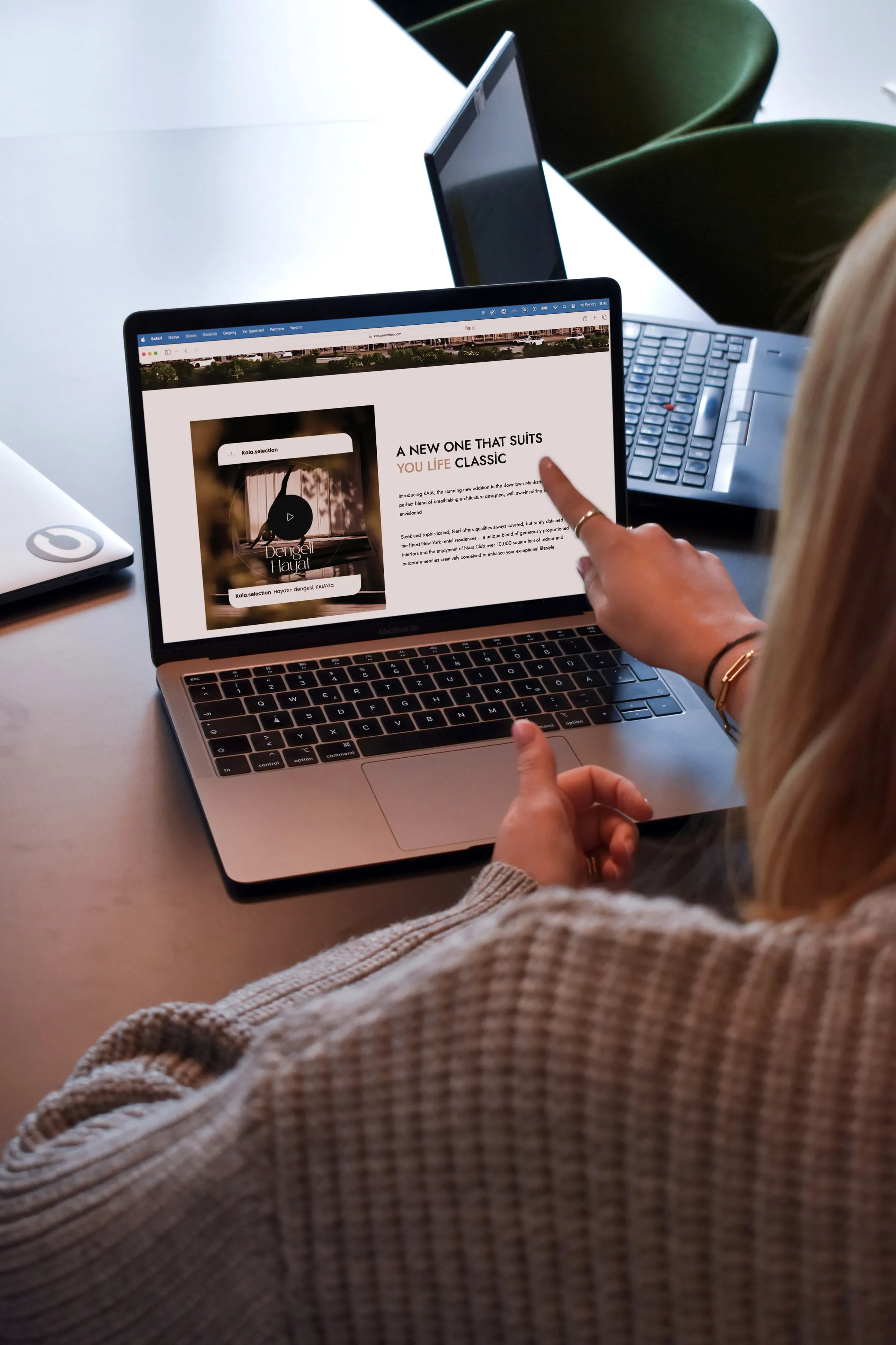 A woman pointing at a page of a live website on her laptop, reviewing an update